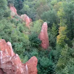 Rochers ocreux et végétation luxuriante dans la vallée des saints boudes. Un paysage minéral et végétal contrasté.