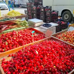 Targowisko pełne świeżych owoców. Duże skrzynie z truskawkami i czereśniami. Sprawdź czereśnie cenę za kilogram!