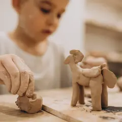 Niño de 2-3 años creando un caballito con arcilla. Divertidas actividades con arcilla para pequeños artistas.