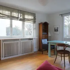 Gemütliche schlafnische im wohnzimmer mit TV, Bücherregal und Esstisch. Große Fenster lassen viel Licht herein.