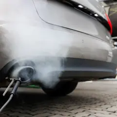 Dym wydobywający się z rury wydechowej samochodu podczas pomiaru emisji.