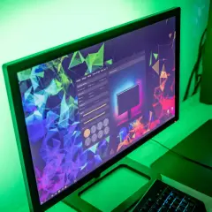 Komputer z podświetleniem w-led i led, tworzący zieloną poświatę. Na ekranie widać program do konfiguracji oświetlenia.
