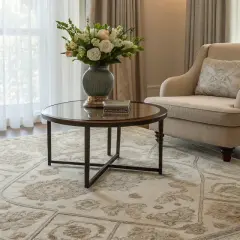 A light-colored rug with a detailed pattern, showcasing the best material for rugs, anchors a cozy living room with two armchairs and a coffee table.
