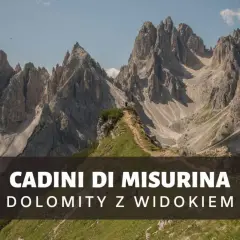 Majestatyczne szczyty Cadini di Misurina w Dolomitach, z wąską ścieżką prowadzącą na zielony pagórek.