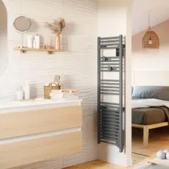 Salle de bain moderne avec meuble vasque, miroir ovale et sèche serviette gris. La puissance du sèche serviette assure des serviettes chaudes.