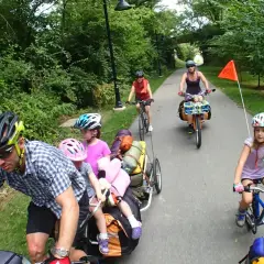 Familia disfrutando de rutas en bici con niños, remolcando equipaje y con niños pedaleando.