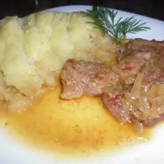 Pyszna cielęcina duszona w sosie własnym z puree ziemniaczanym i gałązką koperku.