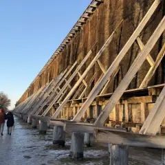 Tężnie w Ciechocinku zimą, ludzie spacerują po zaśnieżonej ścieżce.
