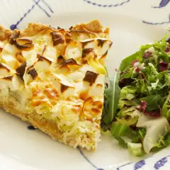 Pyszna tarta z porem i serem, podana z sałatką. Idealna na lekki obiad lub kolację.