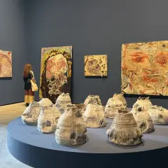 A visitor contemplates abstract artworks and ceramic sculptures at the Venice Biennale 2026.