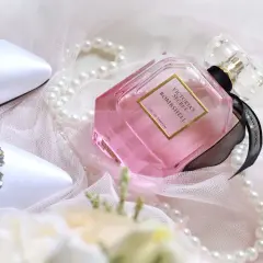 Eleganckie białe buty z kryształkami, różowe oznaczenia perfum Victoria's Secret Bombshell i perły na delikatnym tiulu.