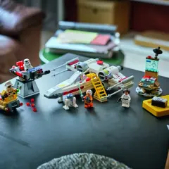 Lego Star Wars X-Wing mit Figuren und einem kleinen, smarten Lego brick auf einer gelben Ladestation.