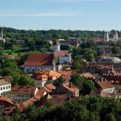 Widok na Wilno z licznymi kościołami i zielenią. Czy na Litwie jest drogo? Tutejsze zabytki i urokliwe uliczki mogą zachęcić do odwiedzin.