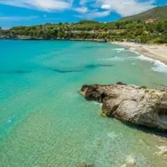 Acque cristalline e una spiaggia dorata incorniciano la **costiera cilentana**, con una torre antica a guardia del mare.
