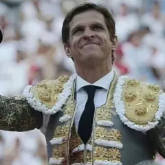 El torero sonríe con su traje de luces, levantando la montera. La fortuna del Juli parece sonreírle en la plaza.