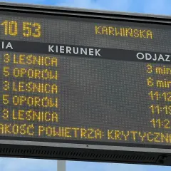 Tablica informacyjna z rozkładem jazdy MPK i informacją o krytycznej jakości powietrza.