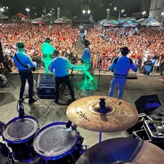 Baciary członkowie zespołu grają na scenie dla tłumu fanów.
