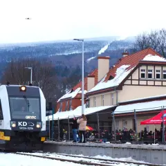 Pociąg KD na stacji w Świeradowie-Zdroju. Jak dojechać PKP? Zimą widok na ośnieżone góry i budynek dworca.