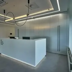 Nowoczesne centrum medyczne z recepcją i minimalistycznym wystrojem.