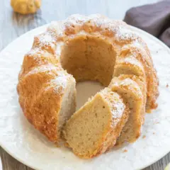 Reife Bananen verwerten: Ein saftiger Bananenkuchen mit Puderzucker bestäubt, daneben liegen frische Bananen.