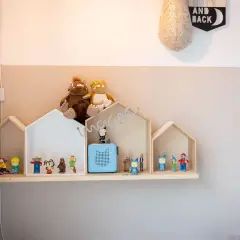 Ein selbstgemachtes Tonie Regal in Hausform, dekoriert mit Figuren und Stofftieren, schafft eine magische Spielzeugwelt.