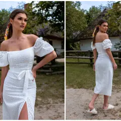 Biała sukienka hiszpanka z haftem, idealna na wesele plus size. Krój podkreślający sylwetkę, z falbankami na rękawach i rozcięciem.