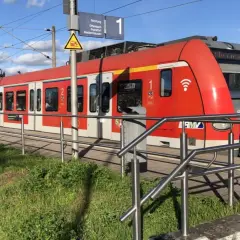 Rote S-Bahn am Bahnsteig. Informiert über den Kinderticket Preis für die Fahrt nach Offenbach, Frankfurt oder Niedernhausen.
