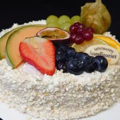 En vacker tårta, perfekt för att dekorera tårta med frukt. Toppad med melon, jordgubbar, blåbär, passionsfrukt och vindruvor.