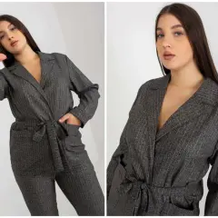 Eleganckie garnitury damskie plus size w prążki. Modelka prezentuje stylowy kombinezon z paskiem.