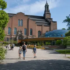 Familj promenerar mot Teknikmuseet med sin imponerande kupol.