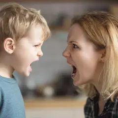 Madre e hijo se miran fijamente, ambos con la boca abierta y expresiones de enfado. ¡Qué importante es no gritar!