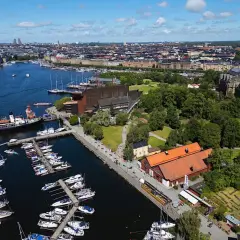 Stockholms hamn med många båtar och en byggnad som liknar Vin & Sprit Museet.