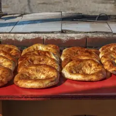 Świeżo upieczone pieczywo gruzińskie, różne rodzaje, z czarnuszką, kuszą apetycznym wyglądem.