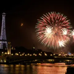 Feux d'artifice spectaculaires illuminent le ciel parisien, avec la Tour Eiffel scintillante et la lune en croissant. Une célébration mémorable pour le 3 avril férié.