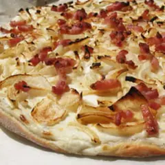 Flammekueche croustillante, garnie d'oignons et de lardons. Une recette simple et savoureuse pour un apéritif ou un repas léger.