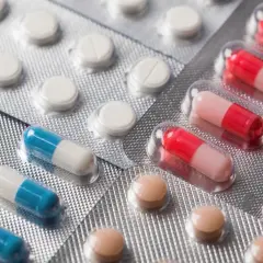 Blistry z białymi tabletkami, niebiesko-białymi kapsułkami i różowo-czerwonymi kapsułkami. Może to być lek afobam.