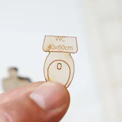 Miniature en bois d'une cuvette de WC, indiquant "WC 40x60cm", une suggestion pour la largeur minimum wc.