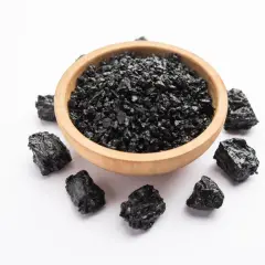 Czarna, grudkowata substancja w drewnianej miseczce i wokół niej. To shilajit, znany ze swoich właściwości.