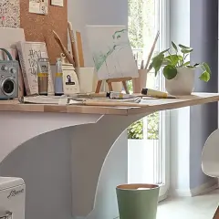 Kreativer Arbeitsplatz mit einem Schreibtisch, der wie ein klapptisch selber bauen wirkt. Buntstifte, Leinwand und ein kleiner Lautsprecher laden zum Malen ein.