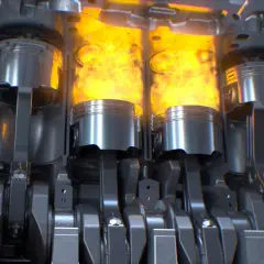 Vue en coupe d'un moteur thermique, montrant les pistons en action avec des flammes vives. Le mécanisme complexe du vilebrequin et des bielles est visible.