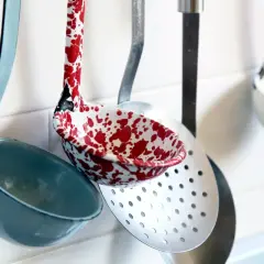 Utensili da cucina nomi: mestoli colorati e forati appesi al muro, pronti per preparare gustose ricette.