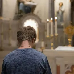 Młody mężczyzna w kościele, zadumany nad tym, czy z masturbacji trzeba się spowiadać.