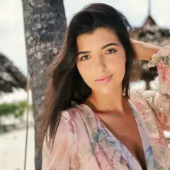 Luiza w kwiecistej sukience na plaży, czuje się jak w hotelu Paradise.