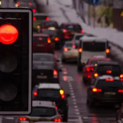 Czerwone światło na fotoradarze na światłach zatrzymuje sznur samochodów w zimowy dzień.