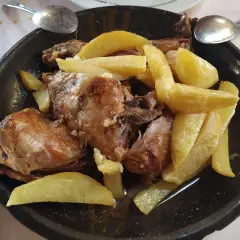 Cordero asado con patatas fritas, un plato típico del rancho el portachuelo.