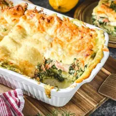 Herzhafte Spinat-Lachs-Lasagne mit goldbraun überbackener Käseschicht, bereit zum Servieren.
