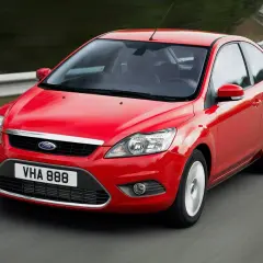 Czerwony Ford Focus MK2 1.6 benzyna w ruchu na krętej drodze.