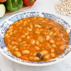 Un plato de alubias con verduras, un guiso casero lleno de sabor y color.