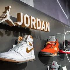 Na ścianie widnieje logo Jordan i nazwa marki. Na półkach wyeksponowane są kultowe buty Jordan Air w różnych kolorach.