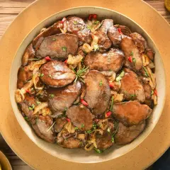 Aksamitne plastry wątróbki po gruzińsku, duszone z cebulką i papryczką chili, udekorowane gałązką rozmarynu.